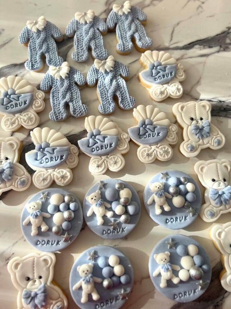 Elegant baby-themed cookies with blue decorations, perfect for a baby shower.